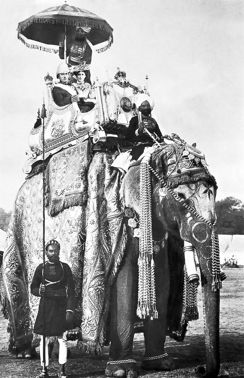 « Le Gouverneur général de l’Inde George Curzon et son épouse Mary Curzon sur le dos de l’éléphant ‘Lakshman Prasad’ à Delhi, le 29 décembre 1902. » (Source : Wikimedia commons) La légende ne mentionne pas les noms des valets indigènes.
