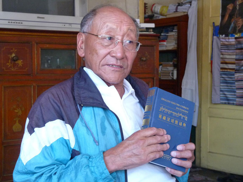 Dans son petit appartement de Lhassa, Tashi Tsering montre la dernière édition de son dictionnaire trilingue (photo : Thérèse De Ruyt, août 2009)