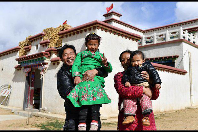 Nijia et les membres de sa famille posent pour une photo devant leur maison au campement de Rongma, un projet local de lutte contre la pauvreté, dans le canton de Gurum à Lhassa, le 2 avril 2020. (Xinhua/Zhan Yan)