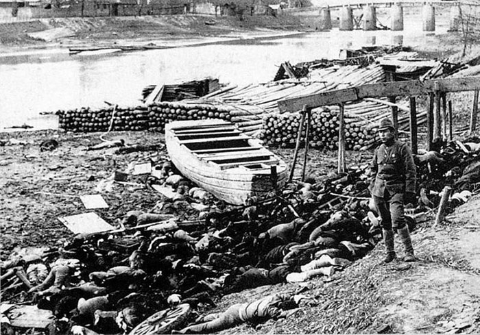 Victimes du massacre sur les rives du Yangzi Jiang avec un soldat japonais debout à côté.