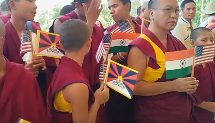 Exilés tibétains brandissant des drapeaux étatsuniens, séparatistes et indiens lors de la visite des élus US (extrait de capture d’écran).