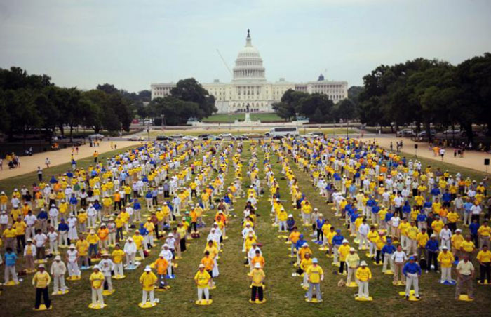 Des centaines de pratiquants de Falun Gong méditent à travers des mouvements corporels pour marquer le 10ᵉ anniversaire de l’interdiction de cette pratique en Chine, le 17 juillet 2009, sur le National Mall à Washington. - AFP.